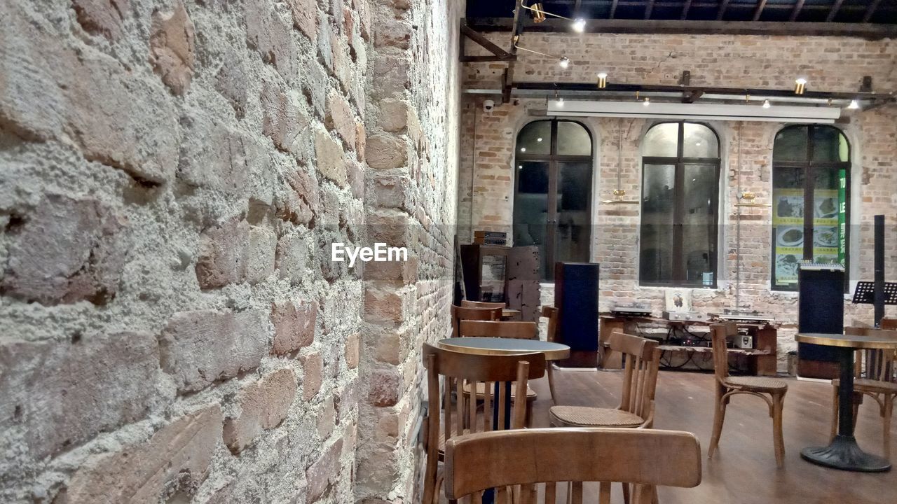 EMPTY CHAIRS AND TABLES AGAINST WALL