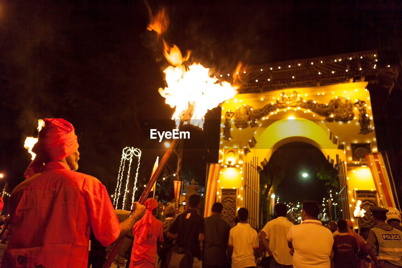 REAR VIEW OF MEN WITH FIRE CRACKERS