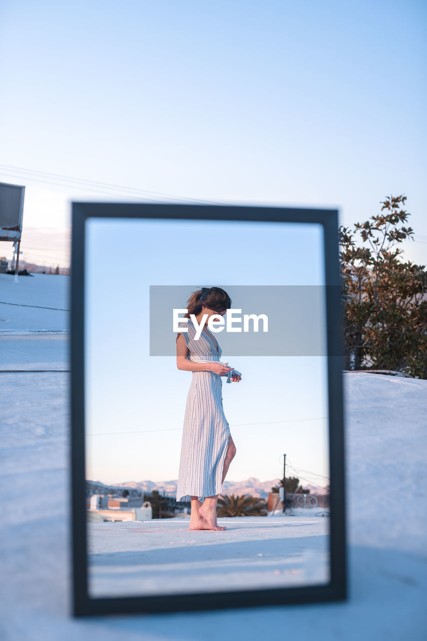 WOMAN STANDING AGAINST SKY