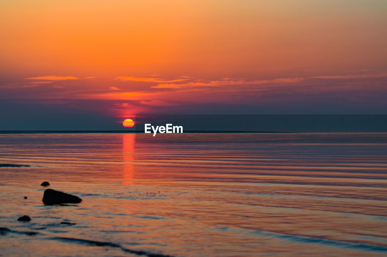 Scenic view of sea against orange sky