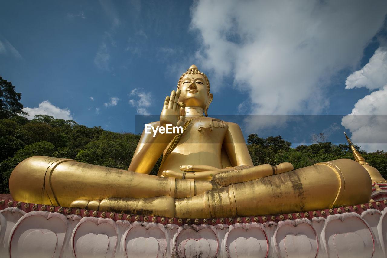 Giant sitting buddha on rang hill temple or wat khao rang  with blue sky in phuket, thailand