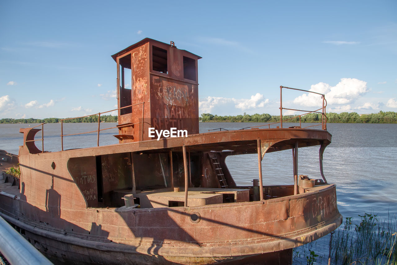 water, sky, nautical vessel, vehicle, boat, nature, sea, transportation, architecture, mode of transportation, watercraft, wood, cloud, no people, day, beach, ship, waterway, built structure, outdoors, blue, travel, land, travel destinations, coast, sunlight