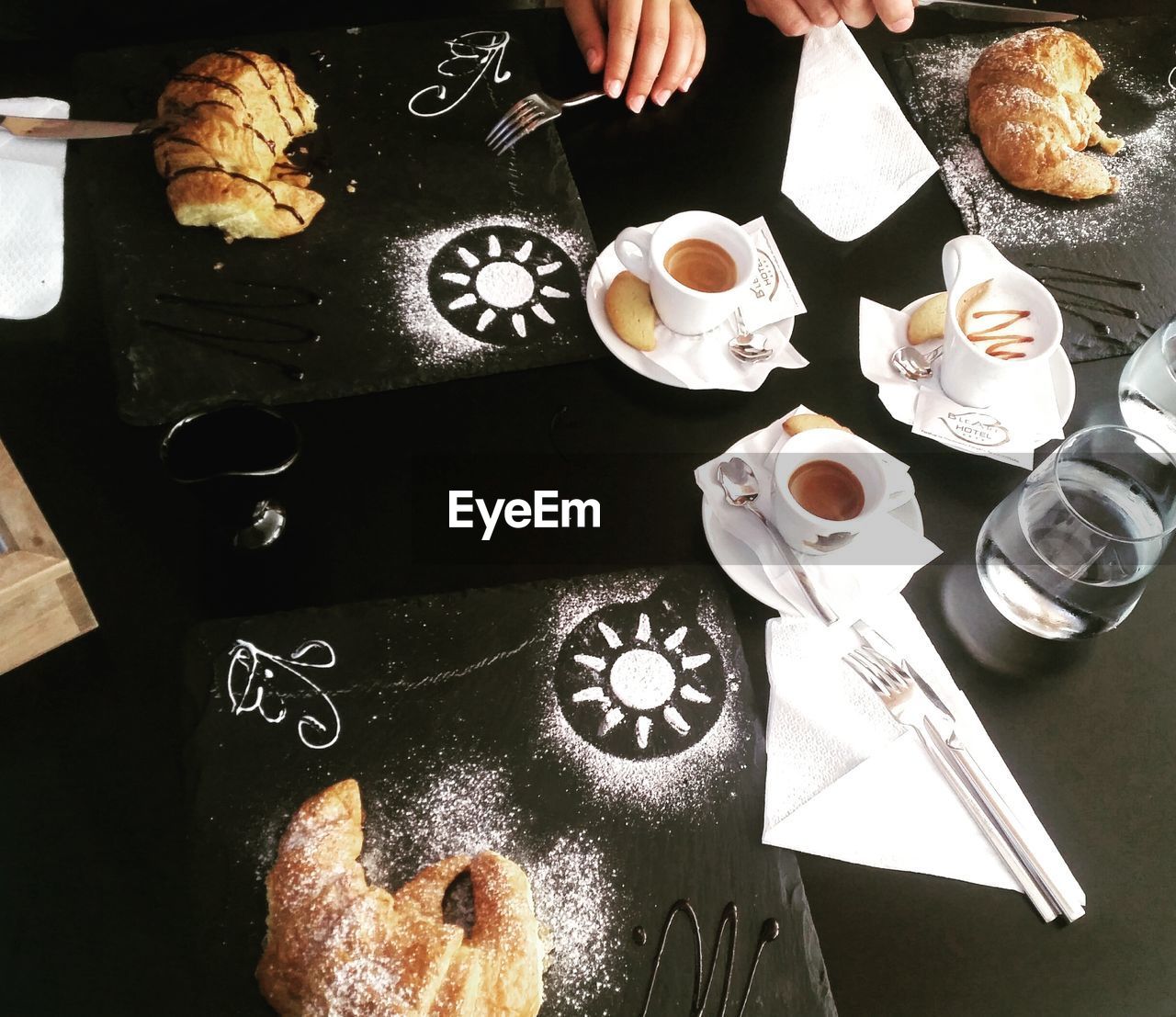 High angle view of coffee cups and croissants on table