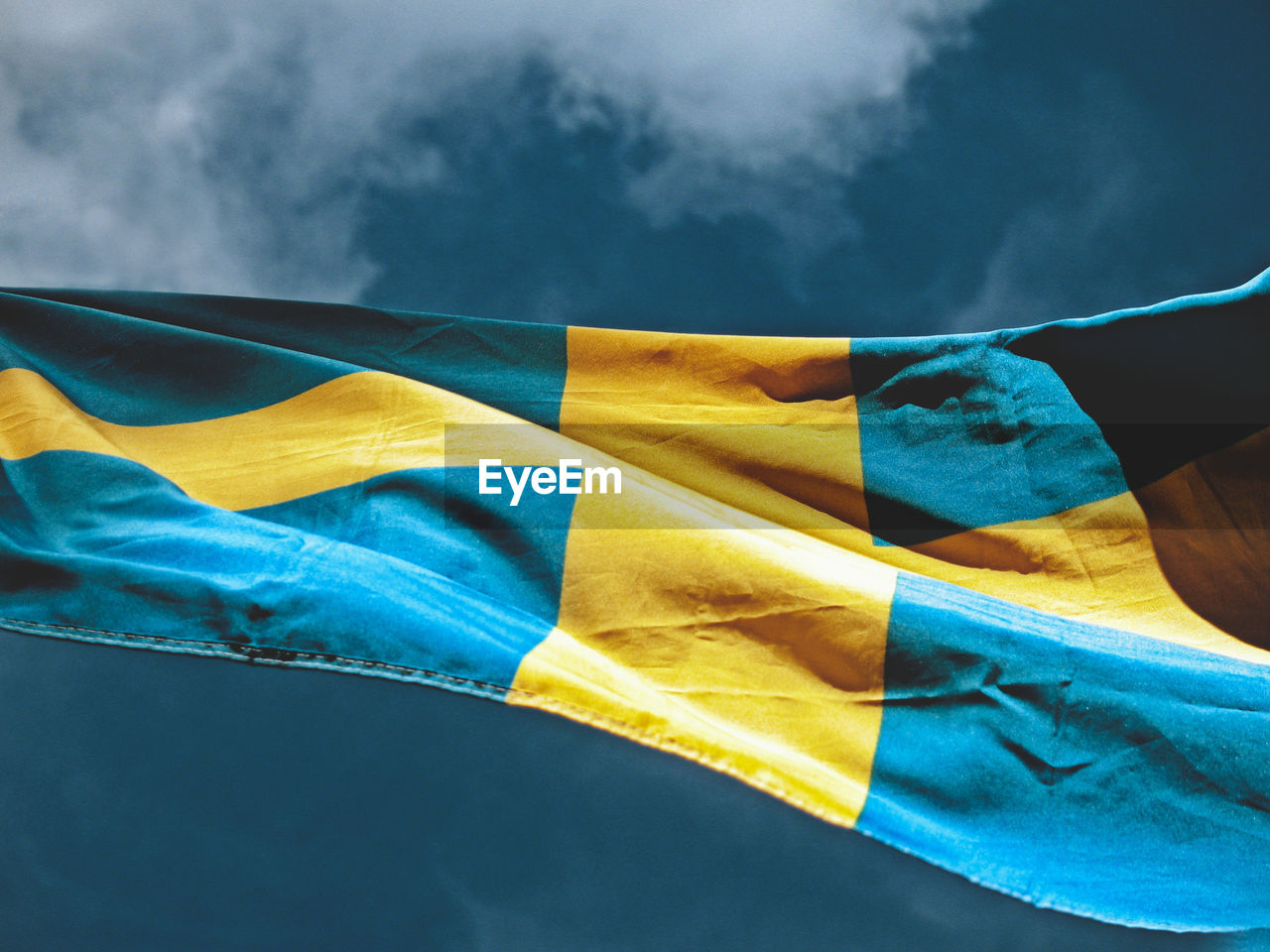 Low angle view of flag against blue sky