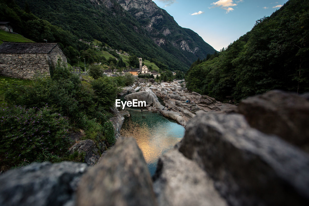 Stream by rocks against mountains