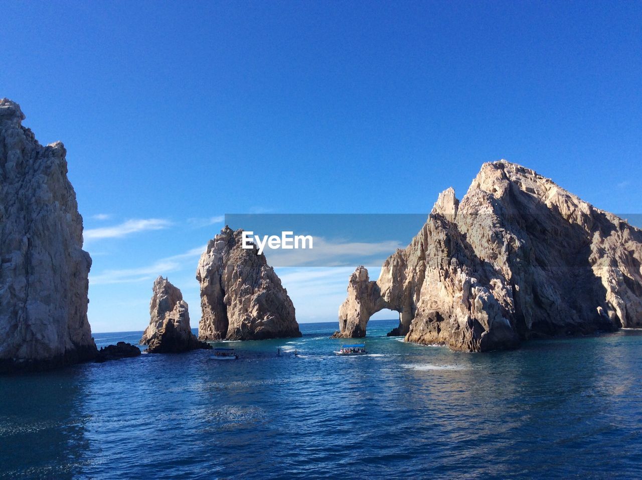 SCENIC VIEW OF SEA AND ROCKS AGAINST BLUE SKY