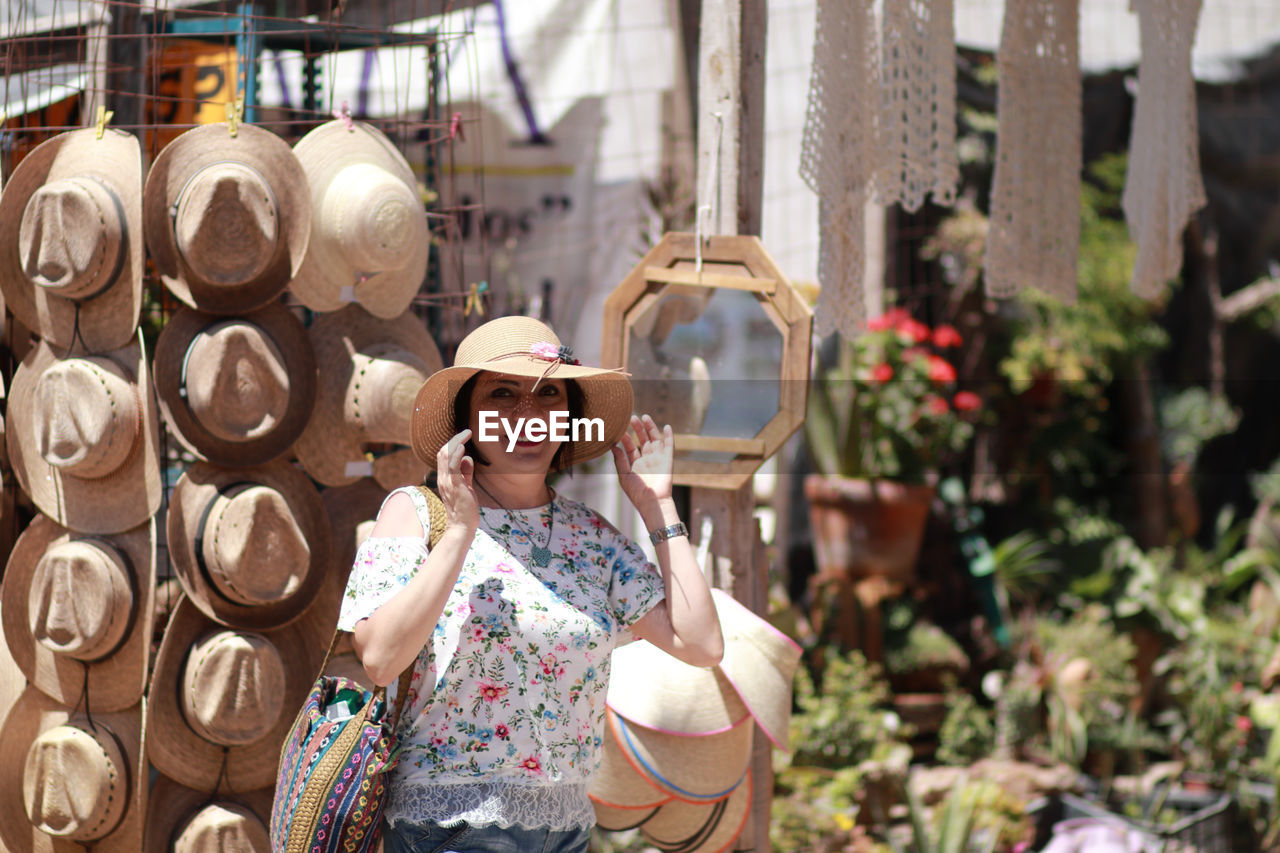 Portrait of smiling woman wearing hat at market