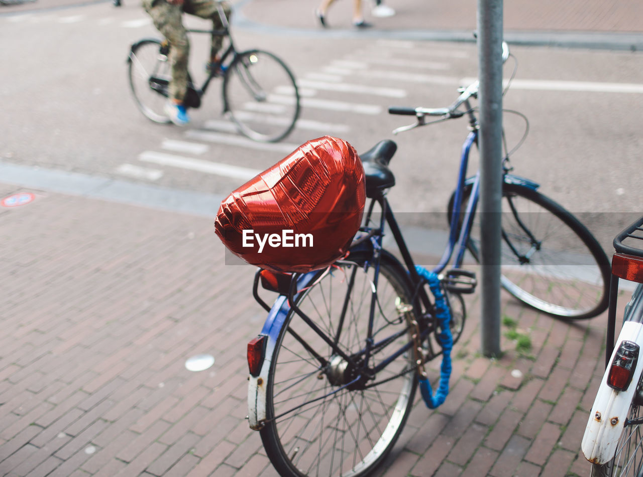 Bicycle on street with heart shaped balloon by pole