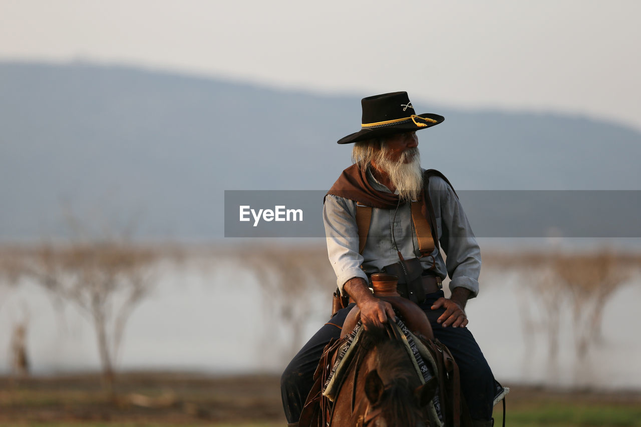 Man riding horse against sky