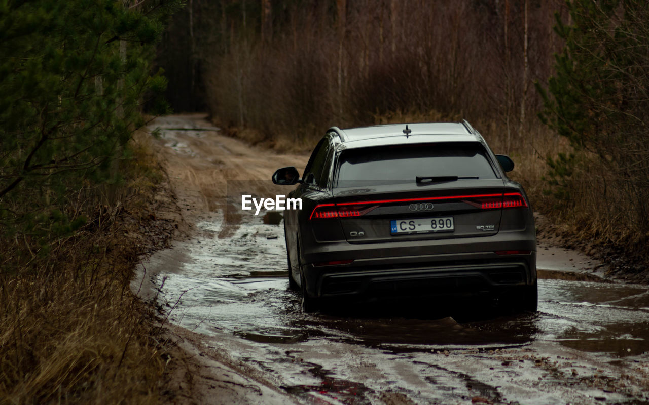 CAR ON ROAD AMIDST LAND