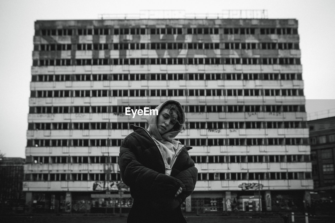 FULL LENGTH PORTRAIT OF SMILING MAN STANDING IN CITY AGAINST BUILDINGS