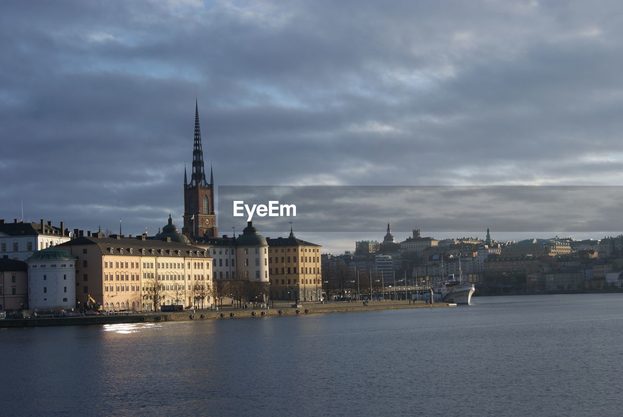 RIVER AMIDST BUILDINGS AGAINST SKY