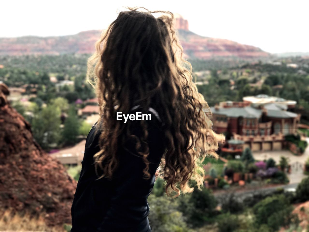 Rear view of woman standing on mountain against sky