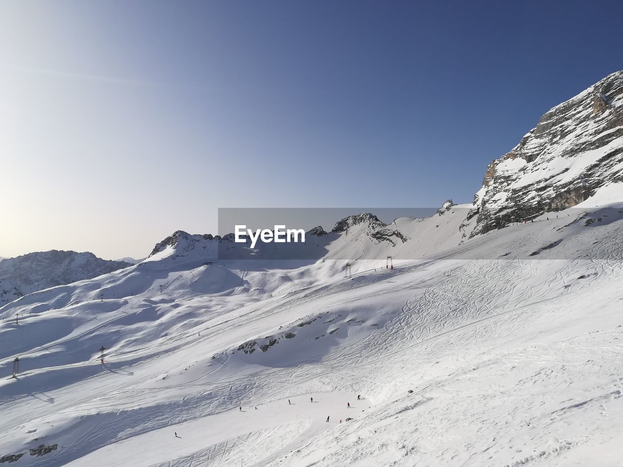 Scenic view of snowcapped mountains against clear blue sky