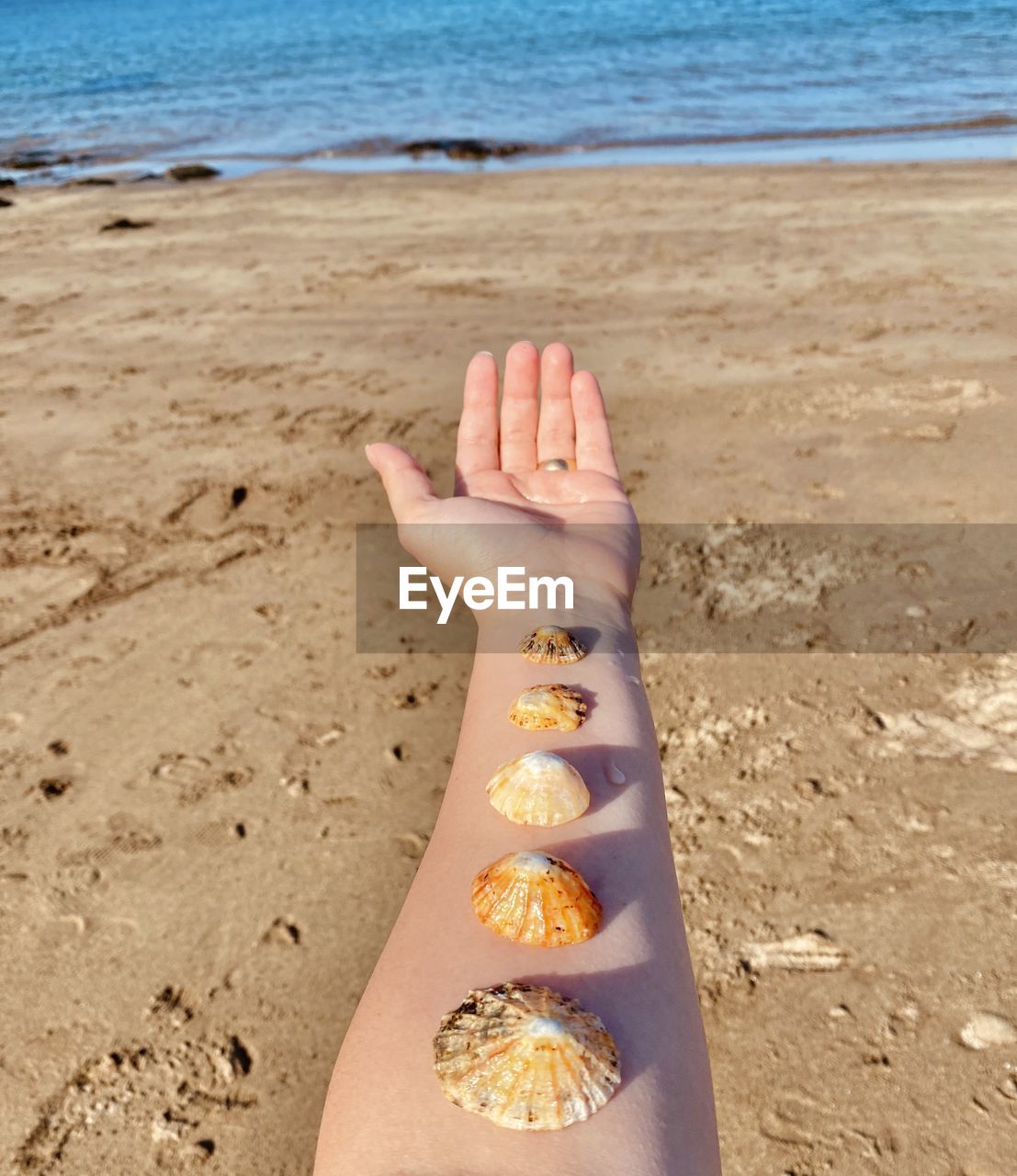 CLOSE-UP OF HAND HOLDING SAND