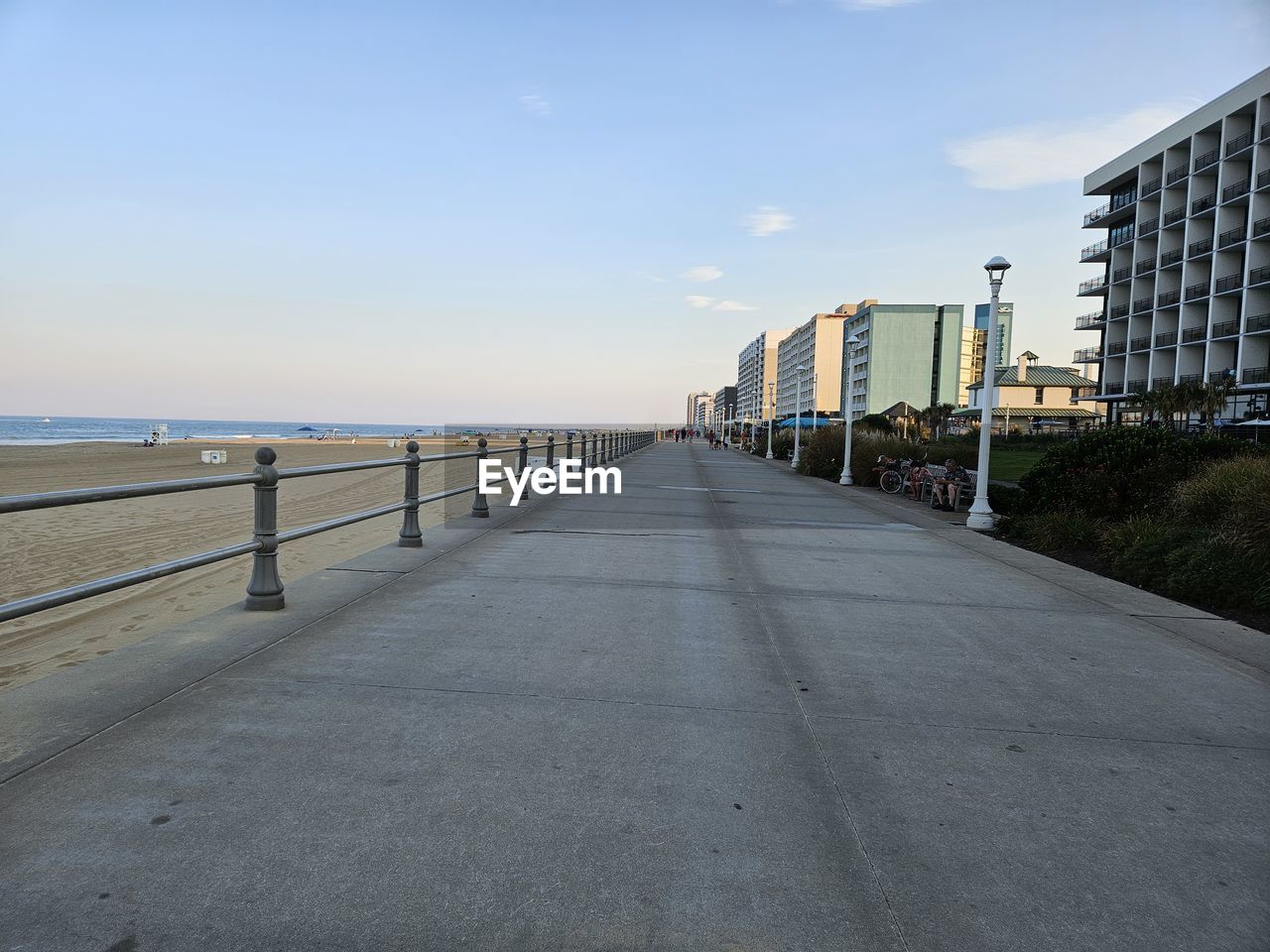 walkway, sky, architecture, boardwalk, built structure, water, city, sea, nature, building exterior, coast, beach, road, building, the way forward, day, no people, transportation, land, outdoors, horizon, cloud, travel destinations, railing, diminishing perspective, footpath, street, urban skyline, vanishing point, travel, tranquility, shore, clear sky, horizon over water