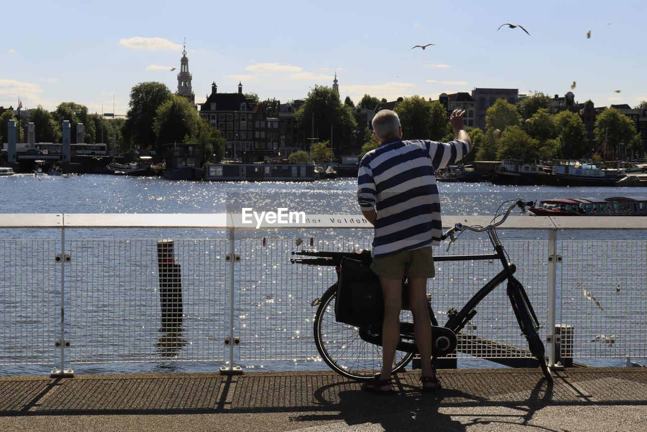 REAR VIEW OF PERSON RIDING BICYCLE