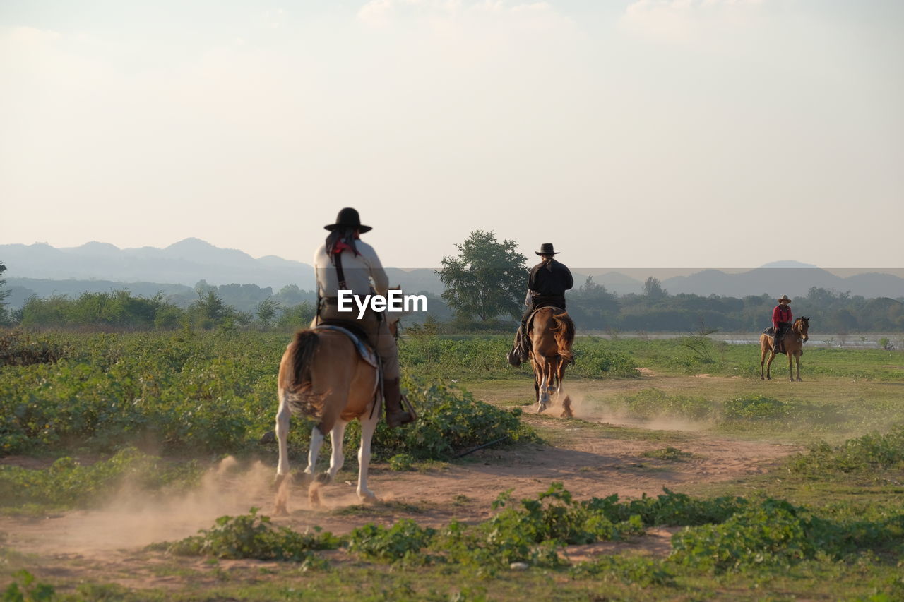 PEOPLE RIDING HORSES ON LAND