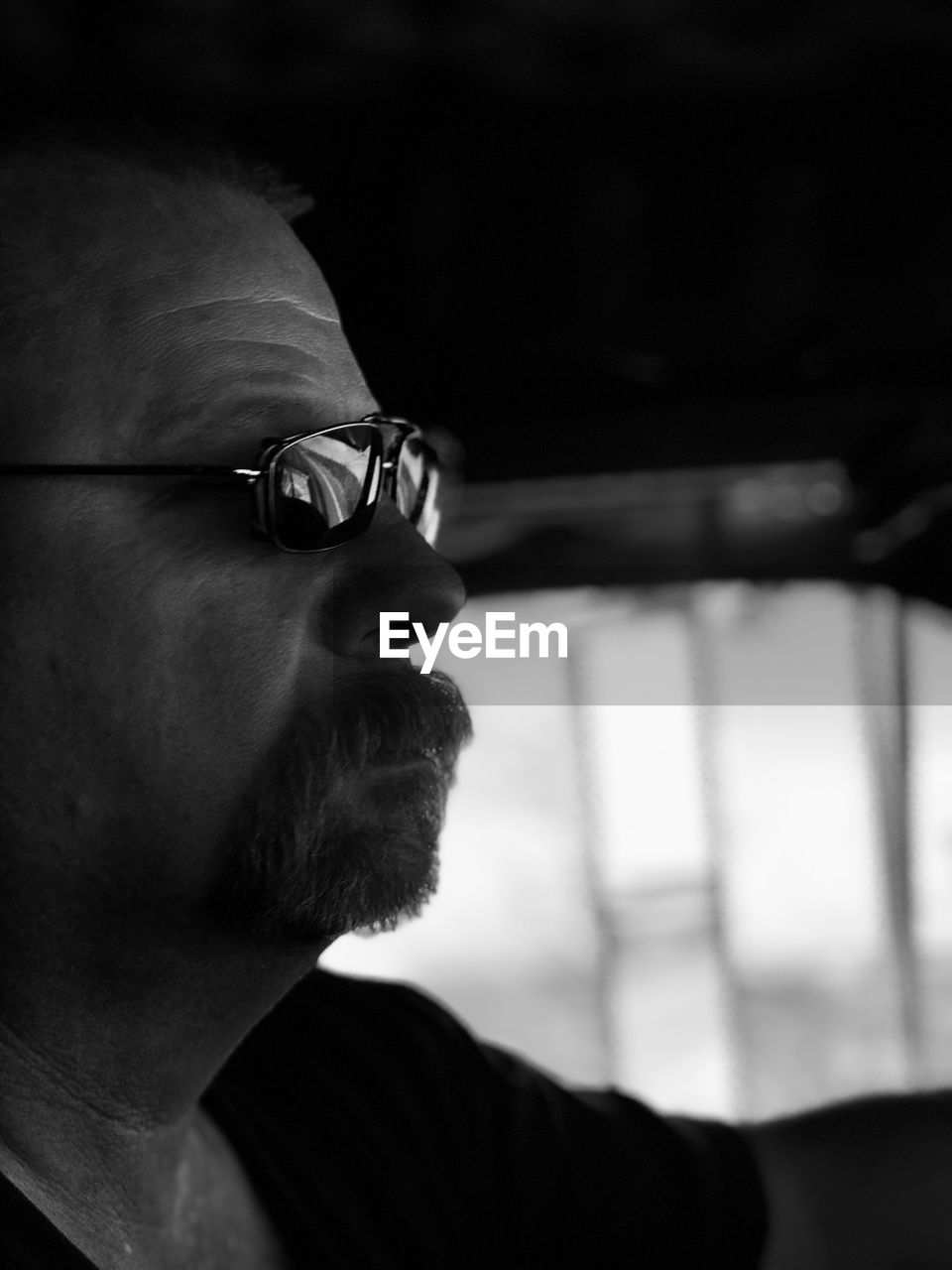 Side view of serious mature man sitting in car