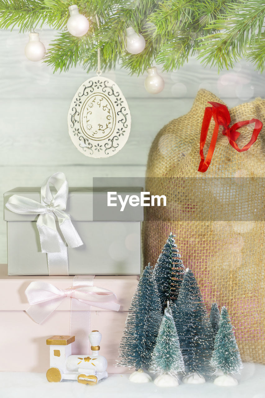 Close-up of christmas gift bag and gift box with ribbon holiday under christmas tree.