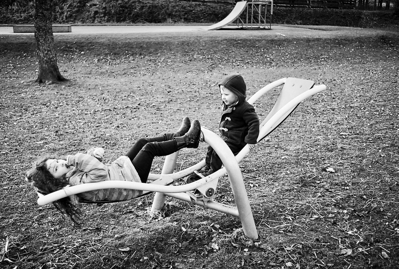 Siblings playing on seesaw at park