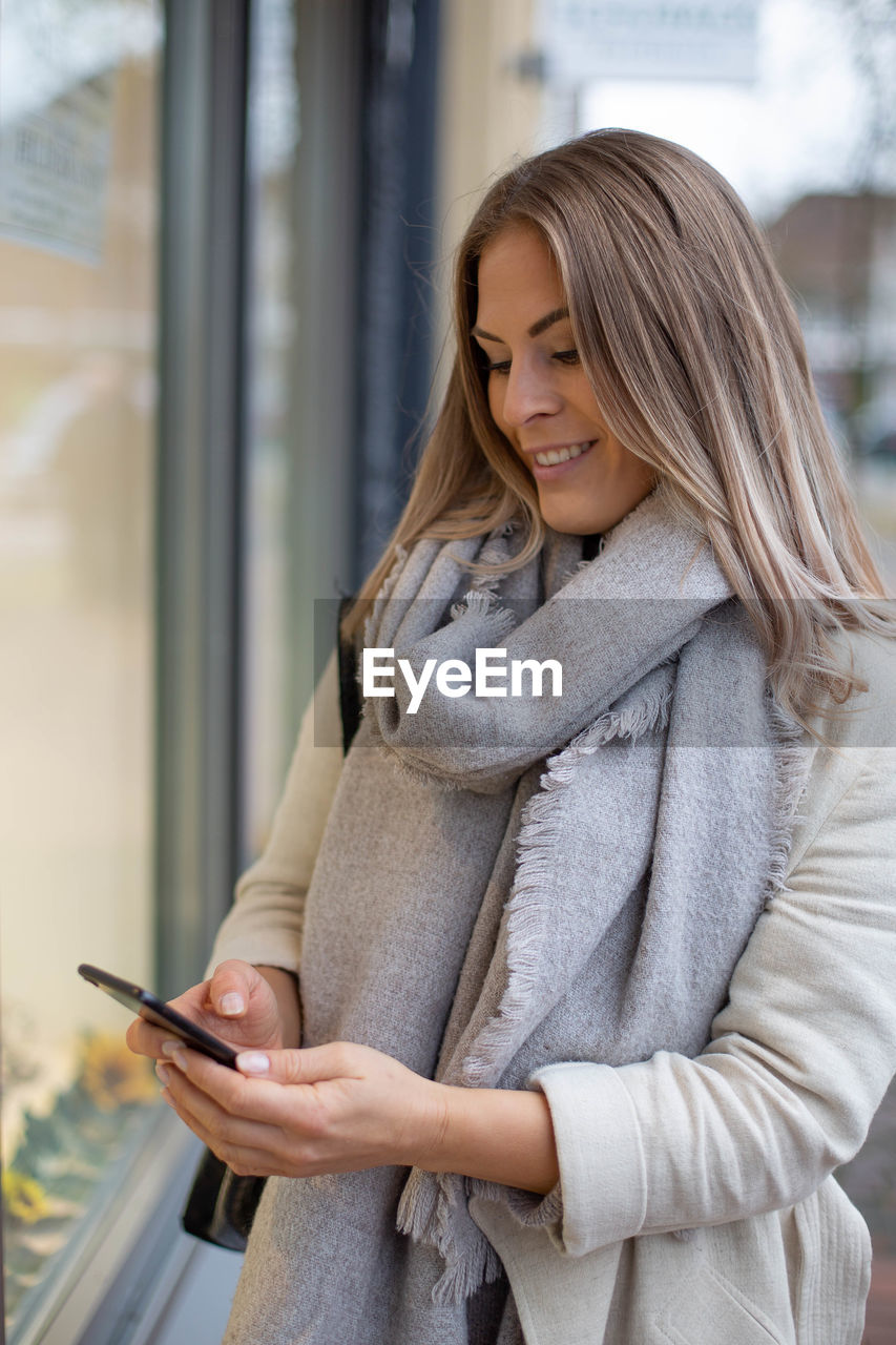 Young woman using mobile phone in winter