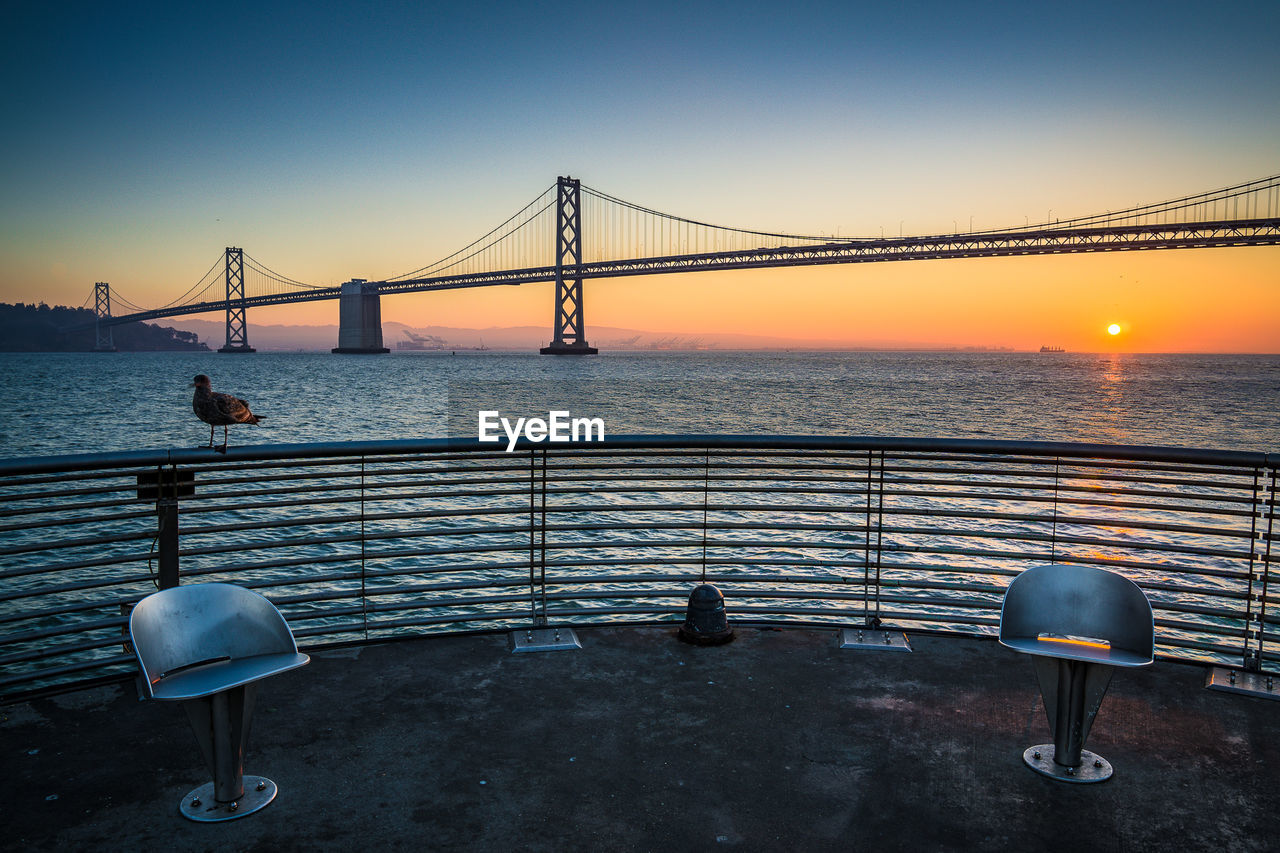 Bay bridge against clear sky at sunrise