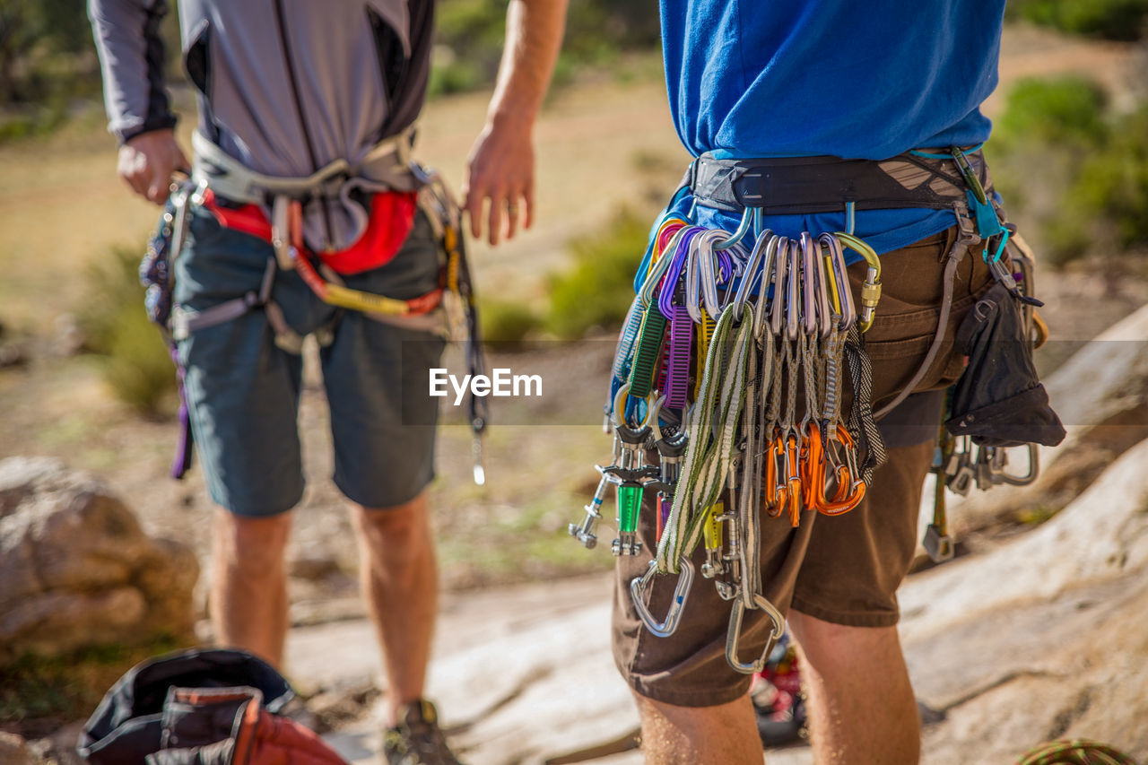 Midsection of men standing with ropes