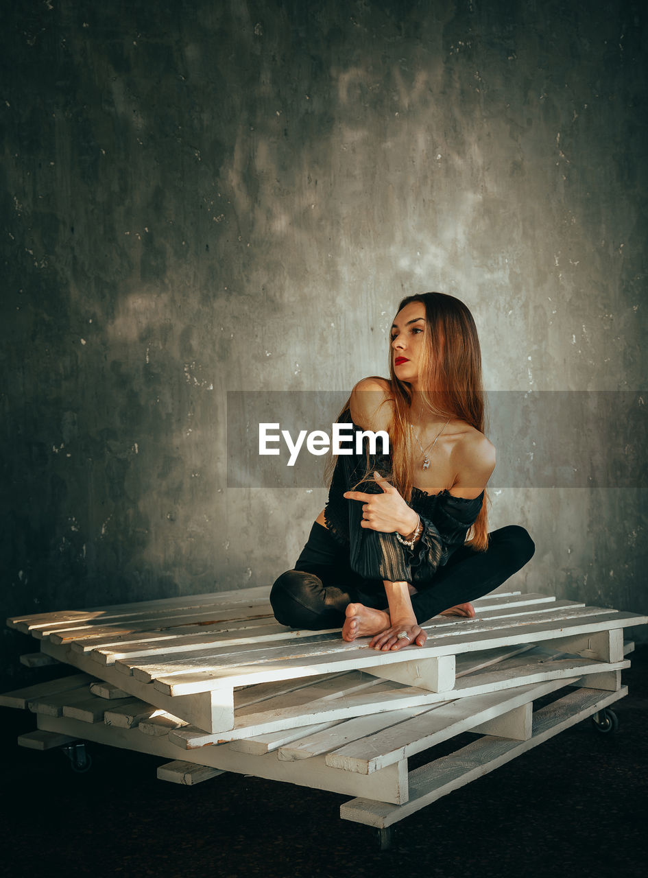 Full length of woman sitting on floor