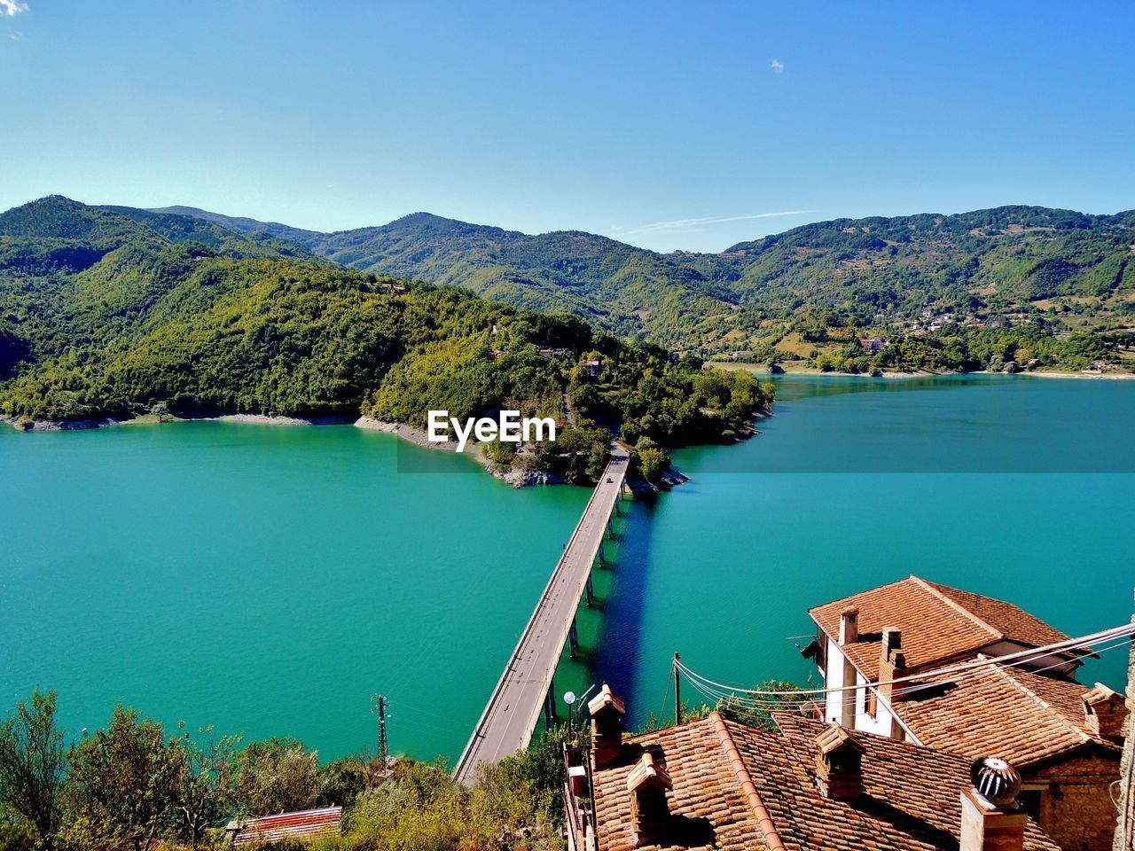 High angle view of lake and trees against blue sky