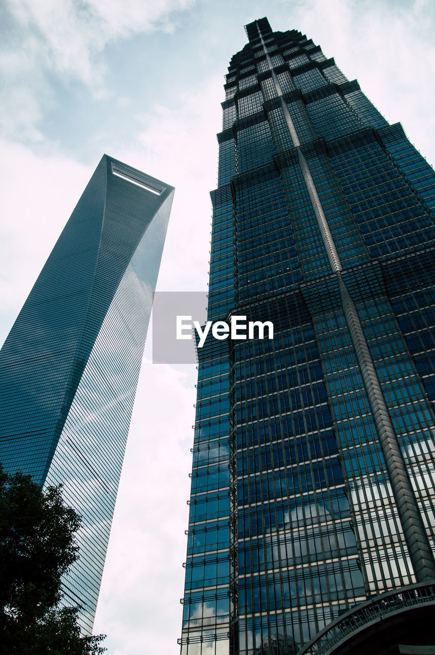 LOW ANGLE VIEW OF MODERN BUILDINGS AGAINST CLOUDY SKY