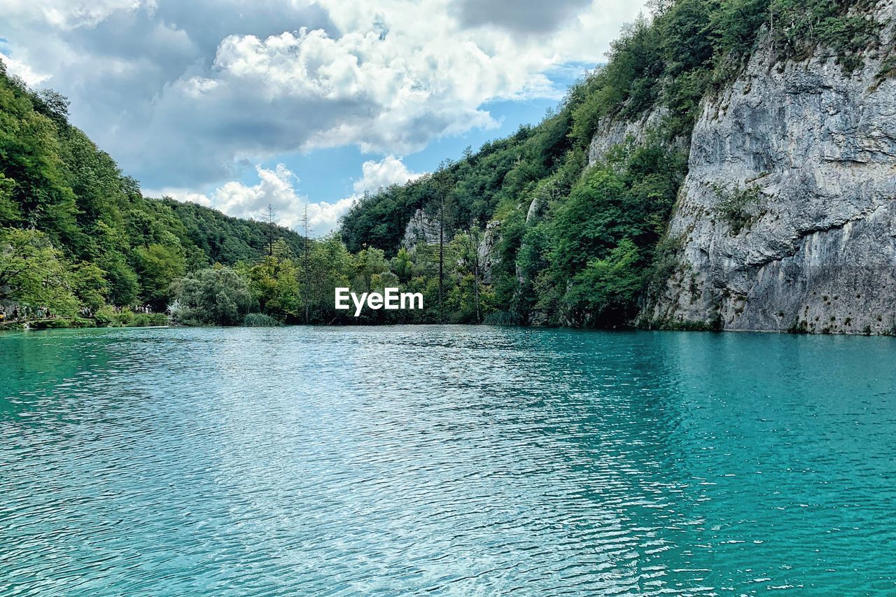 Scenic view of lake by trees against sky