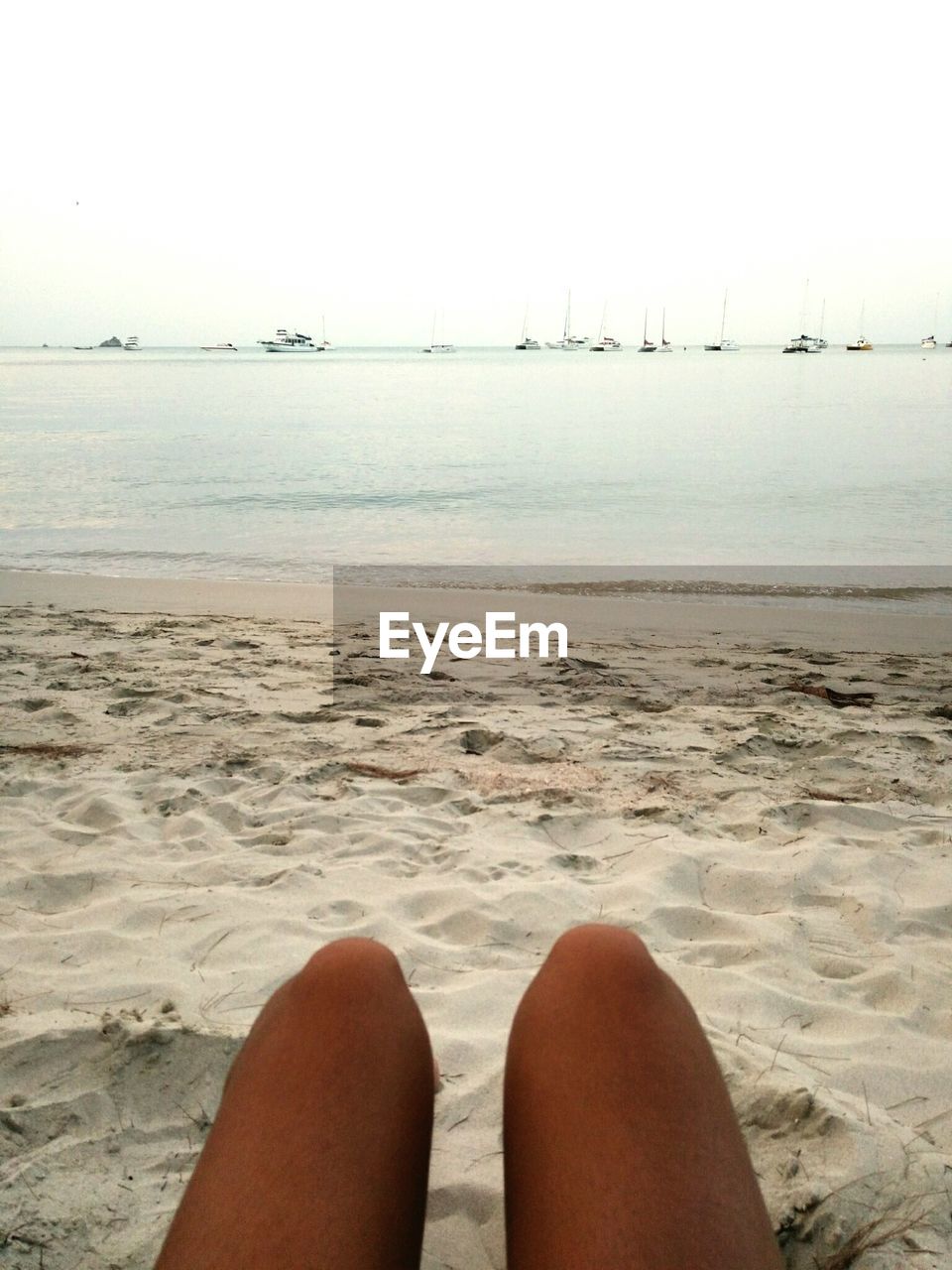 LOW SECTION OF WOMAN RELAXING ON BEACH
