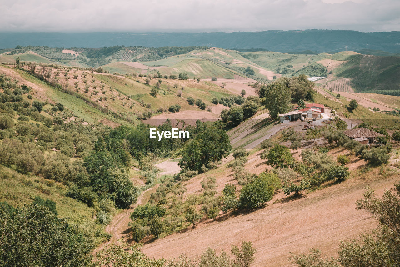 A field in a rural scene surrounded by hills in italy.