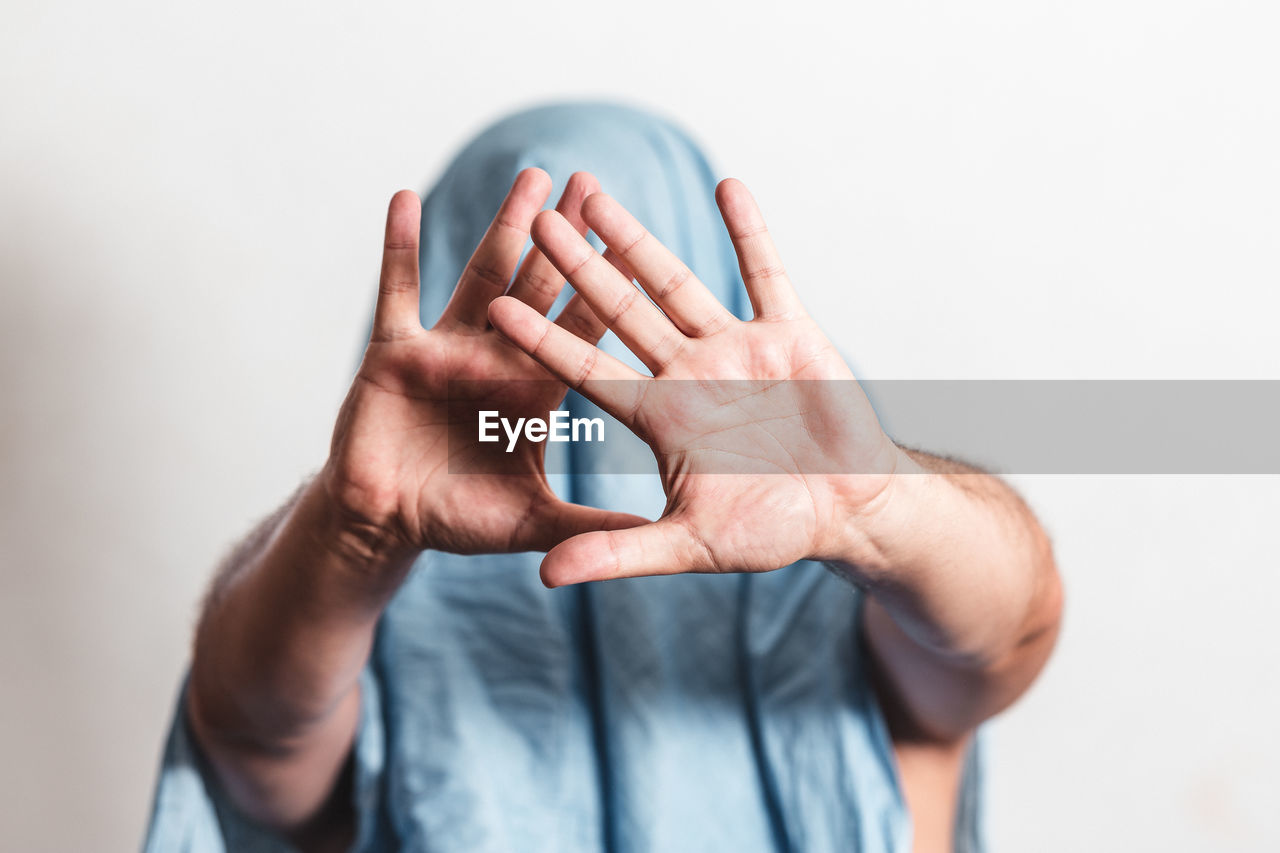 Man showing stop gesture with his face hidden