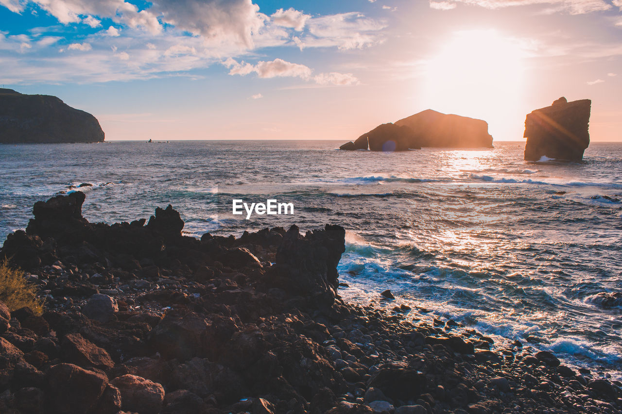 SCENIC VIEW OF ROCKS ON SEA AGAINST SKY