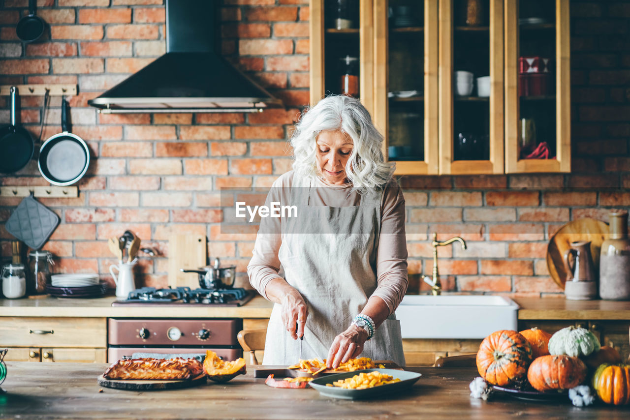 portrait of young woman preparing food in kitchen