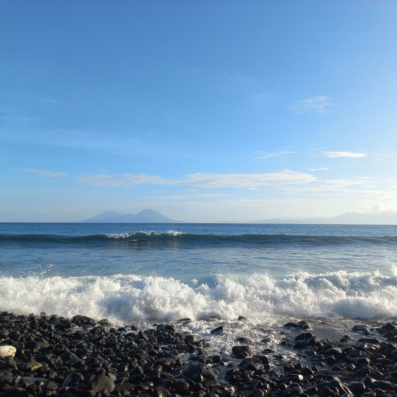 sea, water, sky, horizon, land, beach, ocean, beauty in nature, body of water, scenics - nature, shore, wave, nature, horizon over water, motion, wind wave, coast, water sports, surfing, cloud, sports, tranquility, sunlight, sand, tranquil scene, rock, outdoors, day, idyllic, blue, seascape, non-urban scene, travel destinations