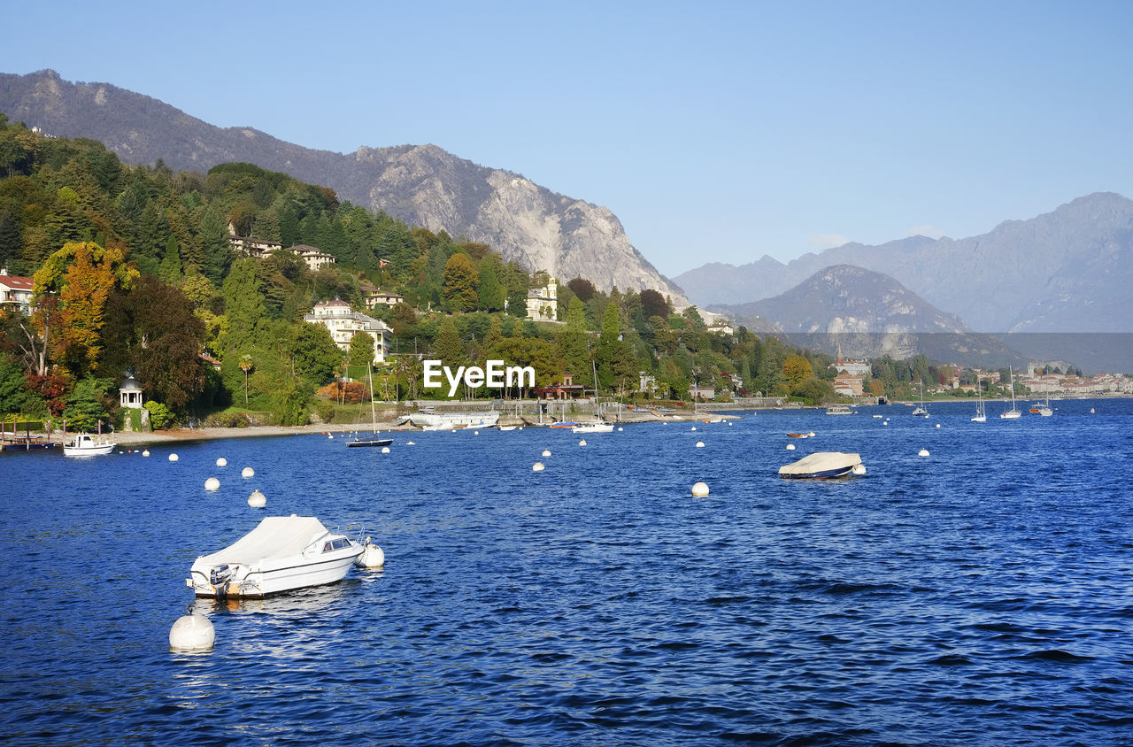 SAILBOATS IN SEA AGAINST MOUNTAINS