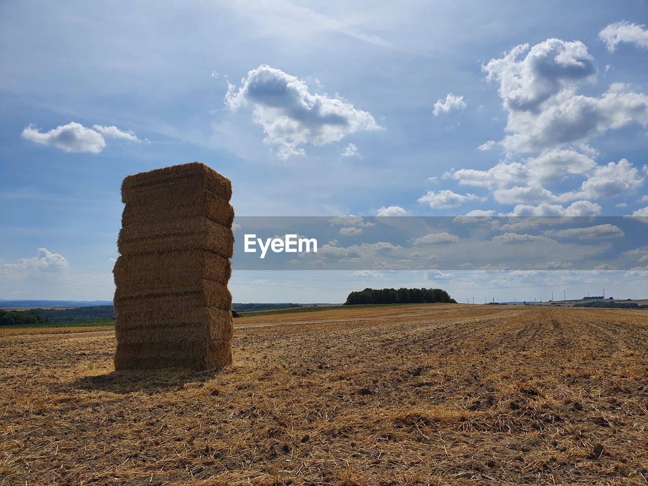 Hay bales on field against sky