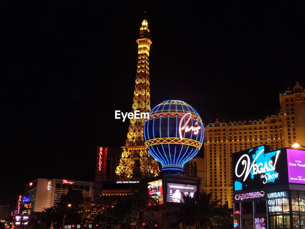 LOW ANGLE VIEW OF ILLUMINATED BUILDINGS AT NIGHT