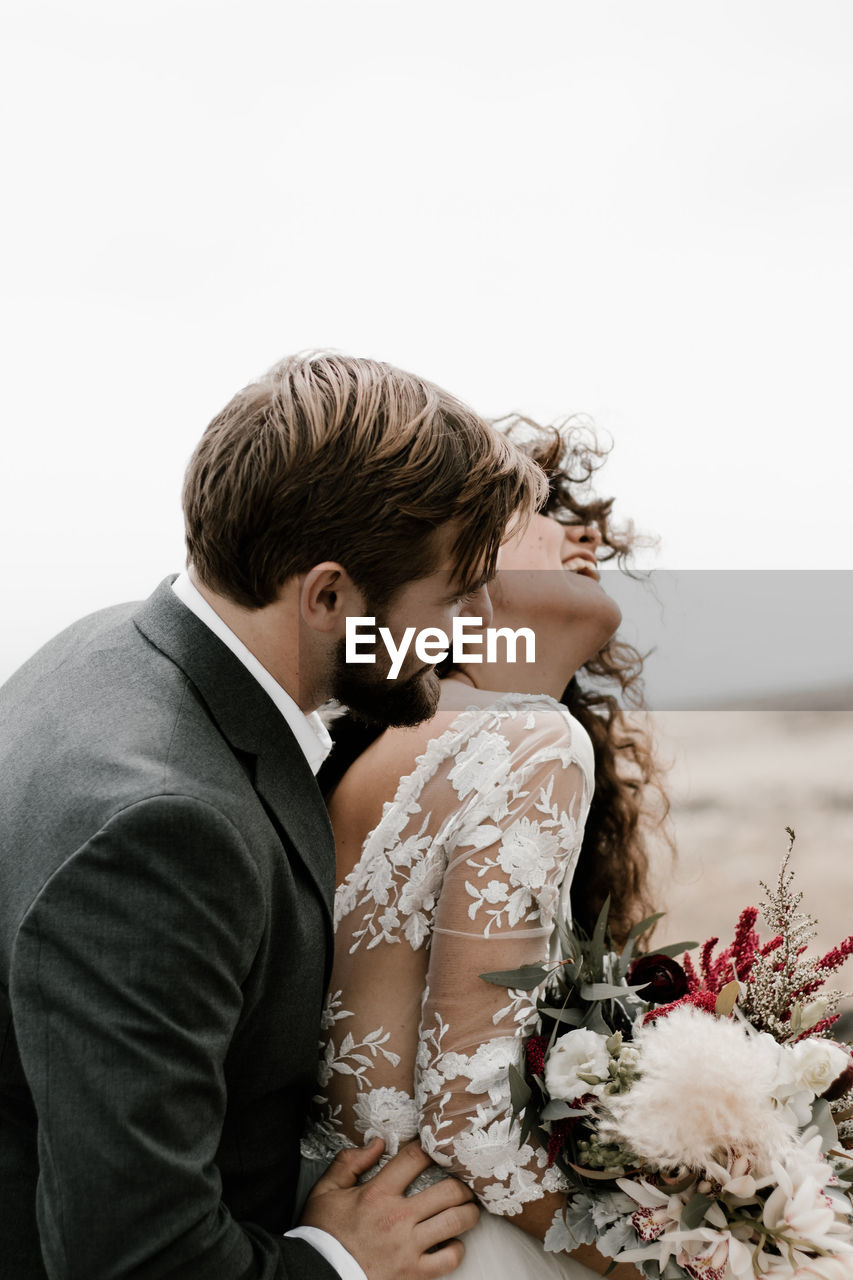 COUPLE KISSING ON A WHITE FLOWER