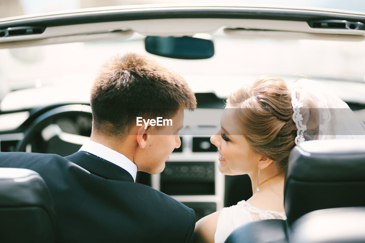 portrait of young woman using mobile phone while sitting in car