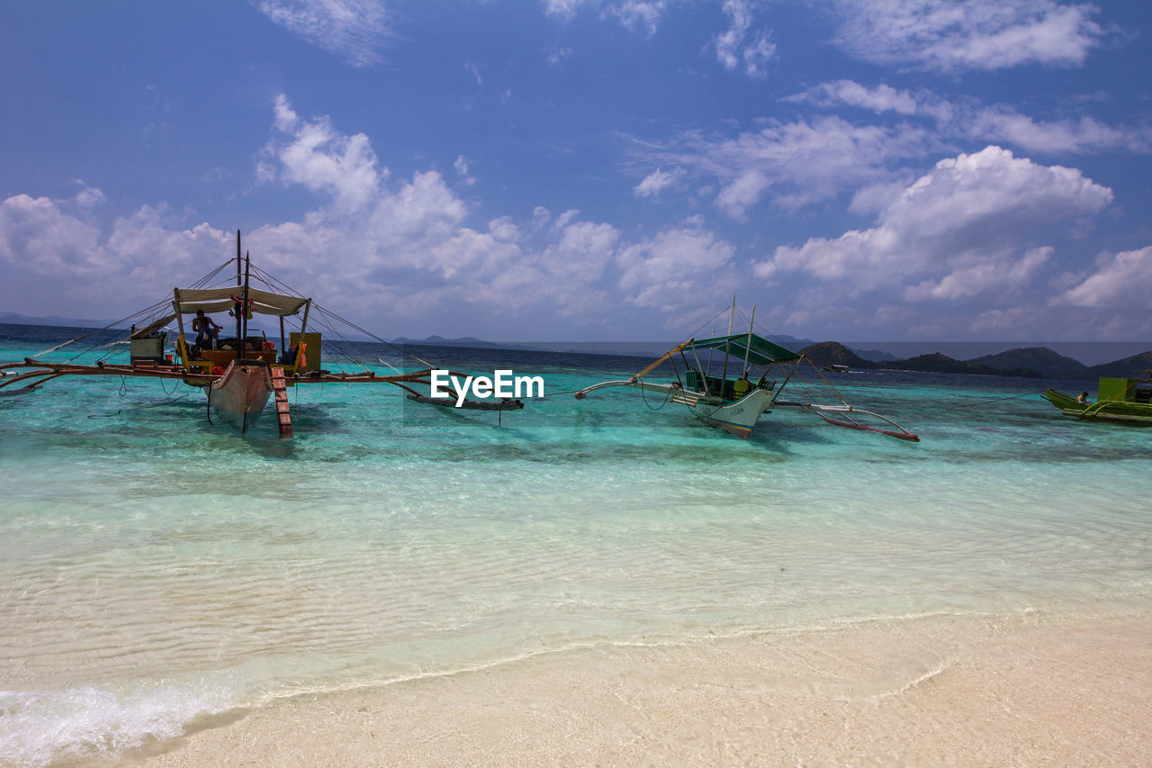 FISHING BOAT ON SHORE AGAINST SKY