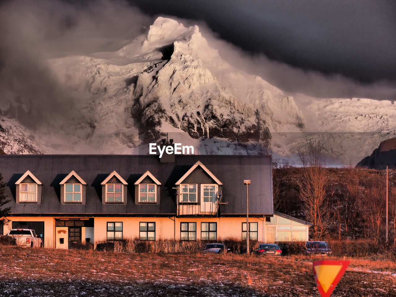 HOUSES BY SNOWCAPPED MOUNTAIN AGAINST SKY