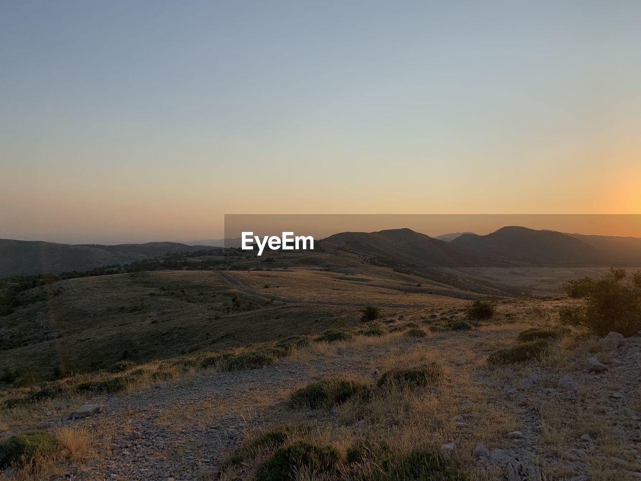 landscape, environment, sky, scenics - nature, sunset, hill, natural environment, wilderness, beauty in nature, nature, land, tranquility, no people, tranquil scene, horizon, non-urban scene, travel, desert, plant, dawn, sun, plateau, travel destinations, clear sky, outdoors, tourism, sunlight, plain, twilight, grass, remote, mountain range, copy space, valley, idyllic, orange color, cloud, steppe, semi-arid