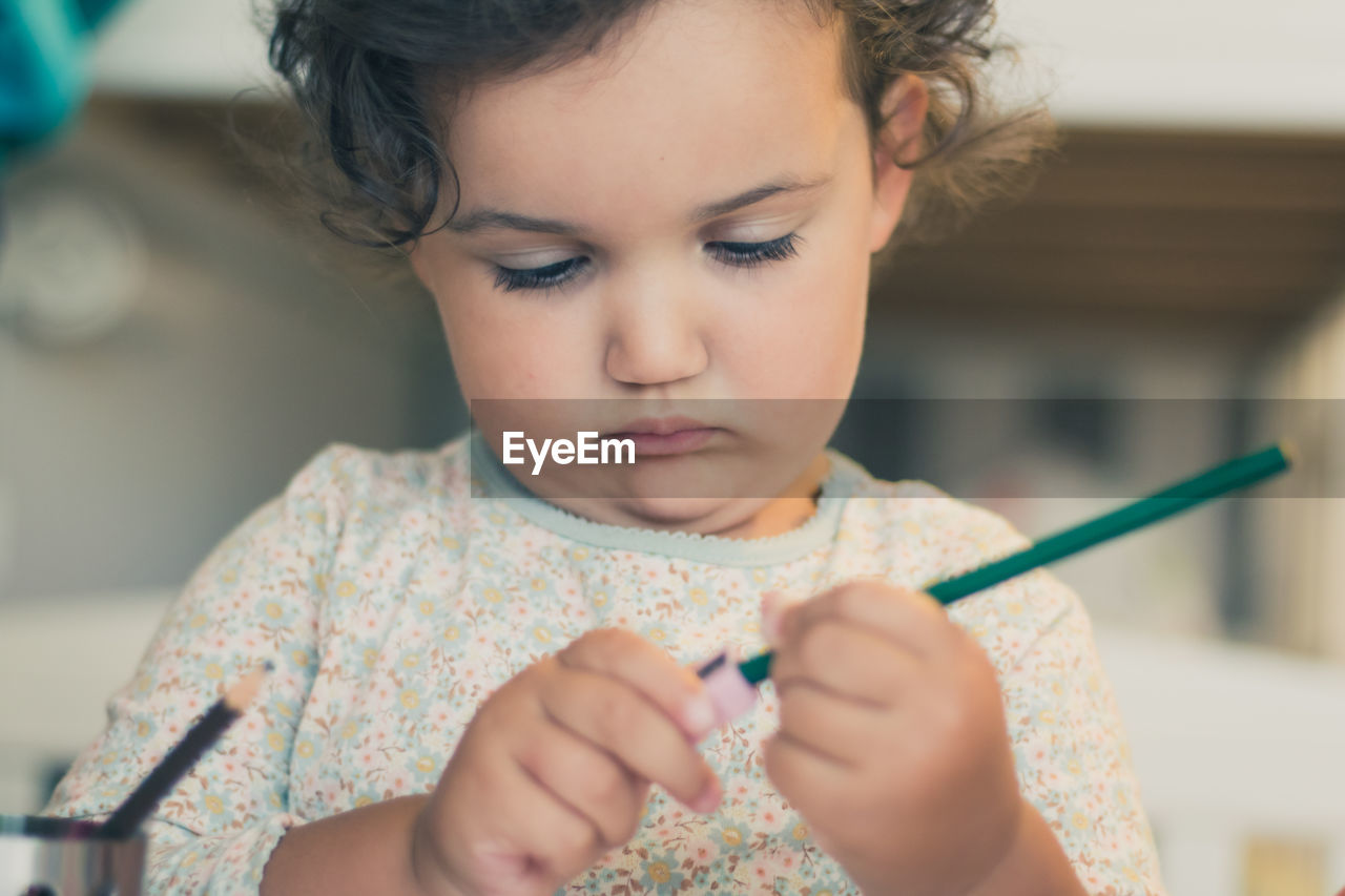 Close-up of girl sharpening pencil