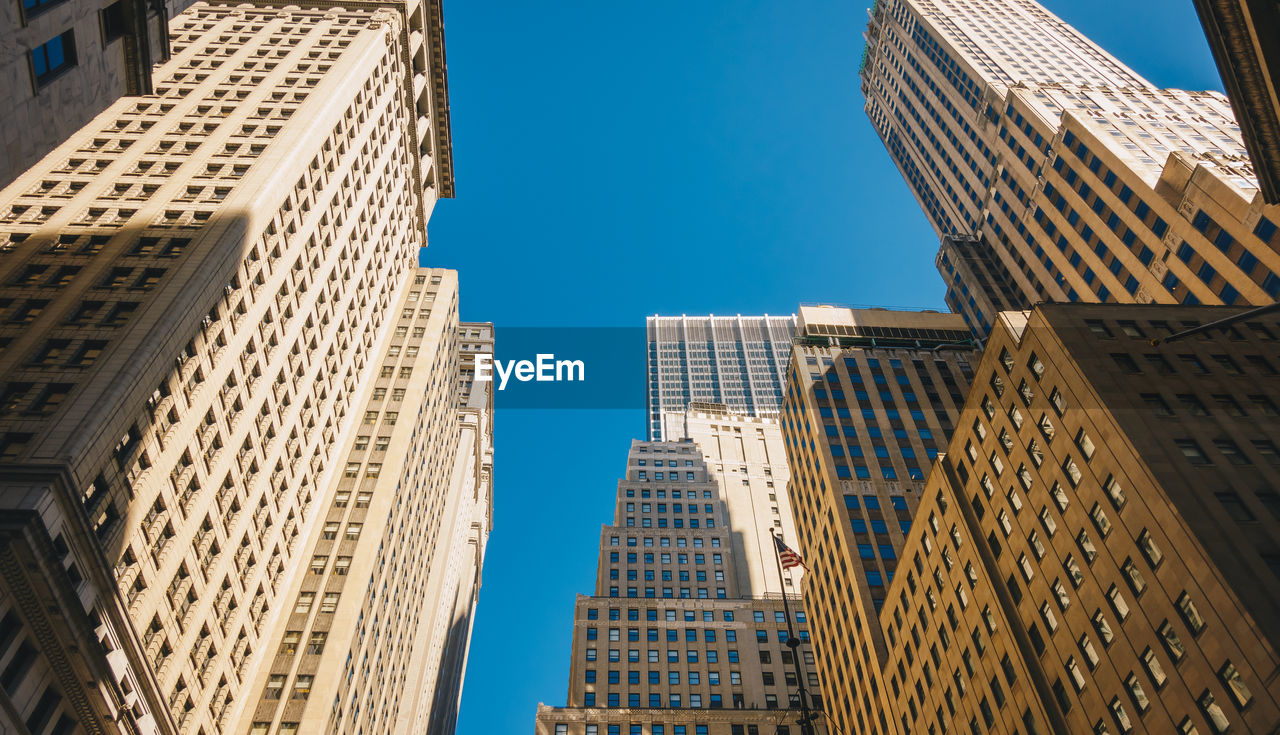 LOW ANGLE VIEW OF BUILDINGS AGAINST BLUE SKY