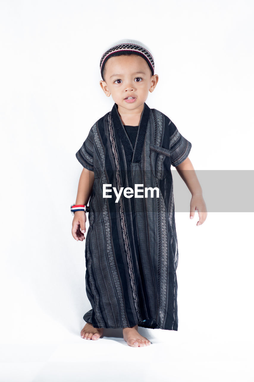 Portrait of boy standing on white background