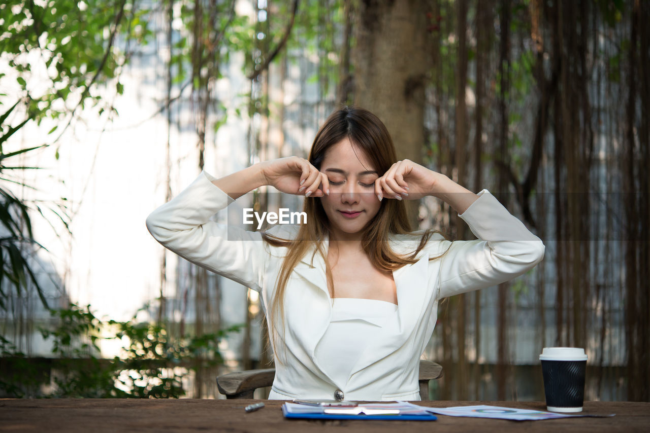 Businesswoman rubbing eyes while sitting at table